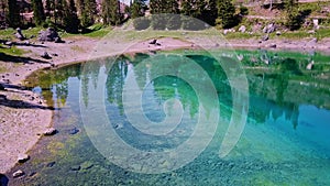 Dolomite Alps in Italy. Aerial drone view of the Lake of Carezza with blue water