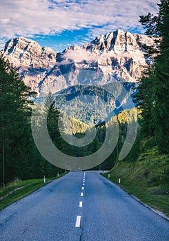 Dolomite Alps in Italy. Beautiful day. The road passes in the co