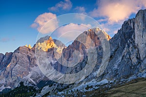 Dolomite Alps, Italy. View of the mountains and high cliffs during sunset. High sharp rocks and soft sunshine. Natural landscape.