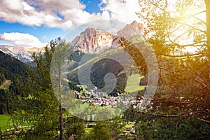 Dolomite alps with a mountain village and green meadows