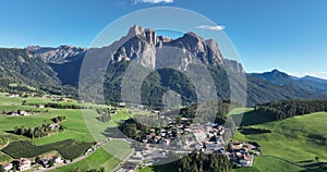 Dolomites alps and small village aerial drone ovrhead view. Italian european rural small town with large high limestone