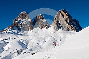 Dolomites covered by snow and sporty people with s