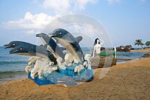 Dolphin and mermaid sculpture on beach