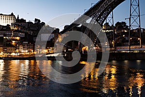 Dom Luis bridge in Oporto at night with quiet waters in Douro River