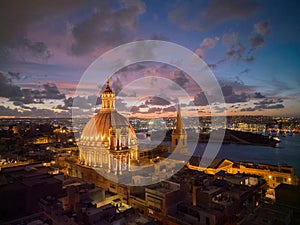 Dome of Basilica in Valletta at sunset aerial towards Manoel island