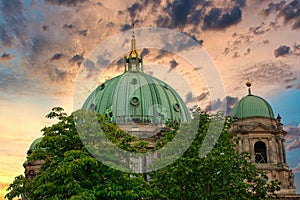 The dome of the Berlin Cathedral behind trees in Berlin