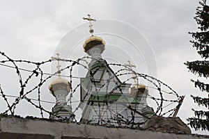 The dome of the church behind barbed wire. The symbol of man\'s faith in God. Religion in prison photo