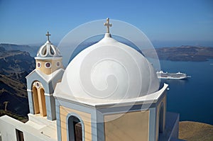 Dome of a church at Oia village with a view of Caldera in the background, Santorini island, Greece.