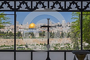 The Dome of the Rock on the Temple Mount, viewed through an ornate window with a cross in the Sanctuary of Dominus Flevit Roman