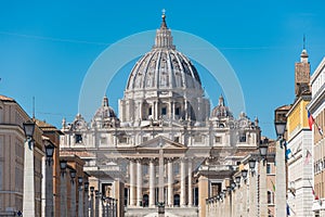 The dome of Saint Peter`s Basilica, statues of saints at St. Peter`s Square, Vatican City view from Via della Conciliazione