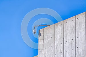 Dome security camera on the rooftop of a school building against clear blue sky