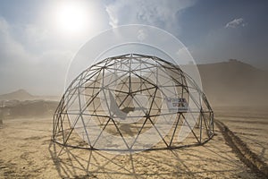 Dome structure in a dusty sand storm with information sign