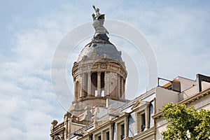 The Dome and top Statues of La Union and el Fenix on Passeig de Gracia, a Residential and office Building, Barcelona - Spain