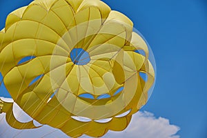 Dome of the yellow parachute on the blue sky.