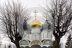 Domes of a Christian church in the Trinity Lavra of St. Sergius against the backdrop of a gloomy sky. Close-up