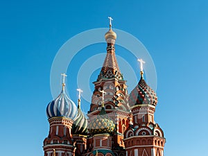 Domes of St. Basil`s Cathedral with golden crosses on a sunny day. Red Square, Moscow, Russia