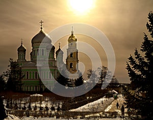 Domes at sunset. Trinity Cathedral of the monastery of St. Seraphim of Sarov Russia in the rays of the setting sun