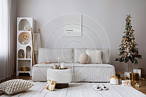 Domestic and cozy christmas living room interior with corduroy sofa, white shelf, mock up poster frame, christmas tree, decoration