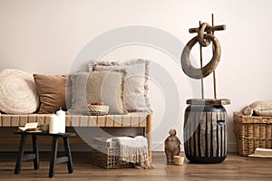 Domestic and cozy interior of meditation living room interior with armchair, beige carpet, pillows, ornament and personal