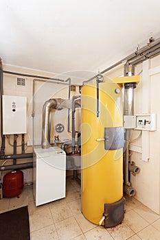 A domestic household boiler room with a new modern solid fuel boiler , heating electric warm water system and pipes.
