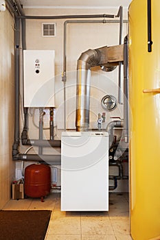 A domestic household boiler room with a new modern solid fuel boiler , heating electric warm water system and pipes.