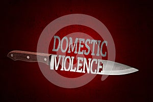 Domestic violence. Kitchen knife with blade of letters on dark red