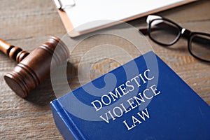 Domestic violence law and gavel on wooden table, closeup