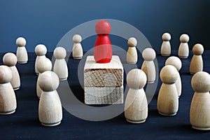 Dominance, power and leadership. Red wooden figurine on blocks photo