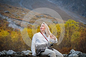 Moment of solitude, girl on the bridge by the waterfall in the mountains