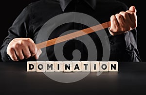 Domination and power concept. Male persons holds a wooden stick with the word domination