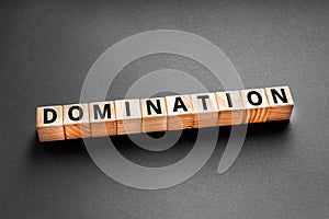 Domination - word from wooden blocks with letters