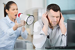 domineering female boss shouting at male office worker