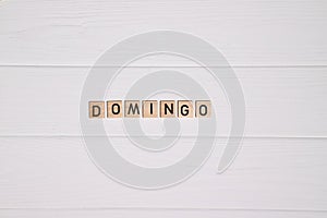 Domingo week day name on white wooden background photo