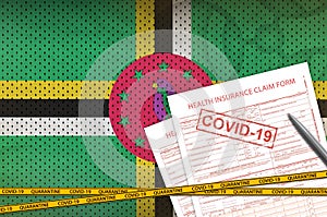 Dominica flag and Health insurance claim form with covid-19 stamp. Coronavirus or 2019-nCov virus concept