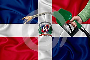 DOMINICAN flag Close-up shot on waving background texture with Fuel pump nozzle in hand. The concept of design solutions. 3d