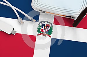 Dominican Republic flag depicted on table with internet rj45 cable, wireless usb wifi adapter and router. Internet connection