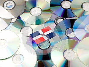 Dominican Republic flag on top of CD and DVD pile isolated on wh