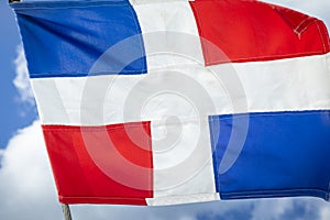 Dominican Republic National Flag Waving against sunny blue sky in Punta Cana