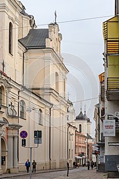 Dominican Street with churches, dwellings and passers-by at noon Saturday in Vilnius