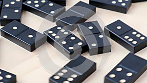 Domino dice black with white dots rotating around on wooden background. Selective Focus. SLow motion. Table games for