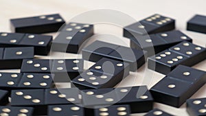 Domino dice black with white dots rotating around on wooden background. Selective Focus. SLow motion. Table games for