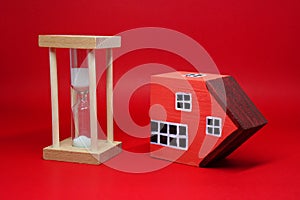 Domino effect of property home with Sand clock hourglass on red background , The impact of financial status and inflation or from