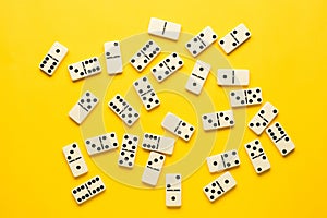 Domino pieces over bright yellow background, top view. Flat lay background.