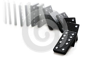 Dominoeffect with falling black dominos on a white background