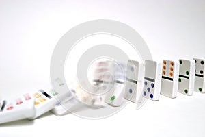Dominoes falling on white