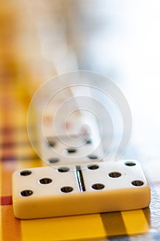 Dominoes on a table with plaid