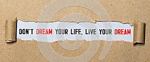 Don't dream your life, live your dream text on red background appears behind torn paper