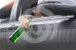 Don`t Drink for Drive concept, Young Drunk man drinking bottle of beer or alcohol during driving the car dangerously