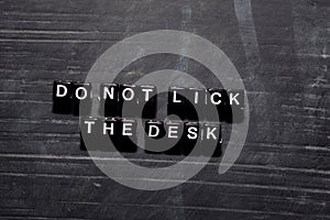 Don`t lick the desk on wooden blocks. Education, Motivation and inspiration concept