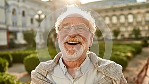 Don`t stop laughing! Portrait of happy and handsome senior man in glasses looking at camera and smiling while standing